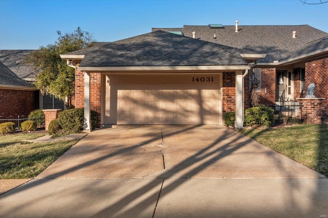 ranch-style home with brick siding, roof with shingles, concrete driveway, and an attached garage