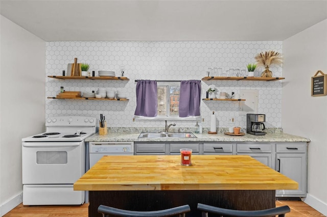 kitchen with light hardwood / wood-style floors, sink, white appliances, and decorative backsplash