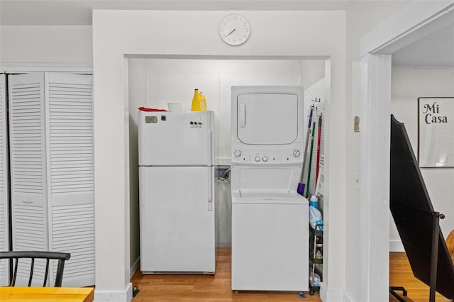 laundry area featuring light hardwood / wood-style flooring and stacked washer and clothes dryer