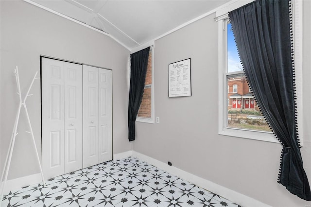 unfurnished bedroom with lofted ceiling and a closet