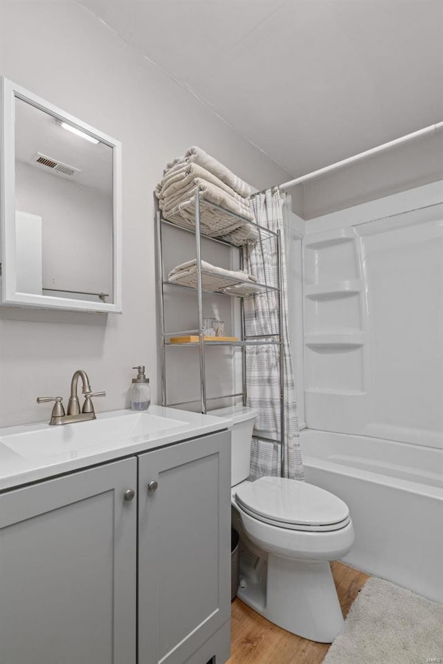 full bathroom with vanity, hardwood / wood-style floors, toilet, and shower / bath combo with shower curtain