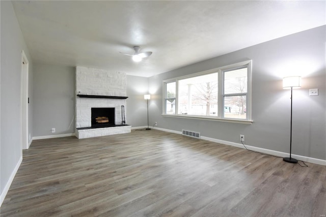 unfurnished living room with hardwood / wood-style flooring, a fireplace, and ceiling fan