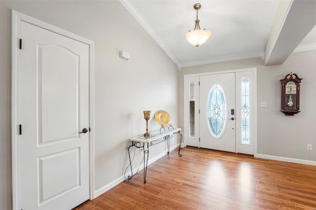 entryway with ornamental molding, light wood-type flooring, and baseboards