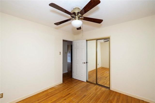 unfurnished bedroom featuring a closet, baseboards, ceiling fan, and light wood finished floors