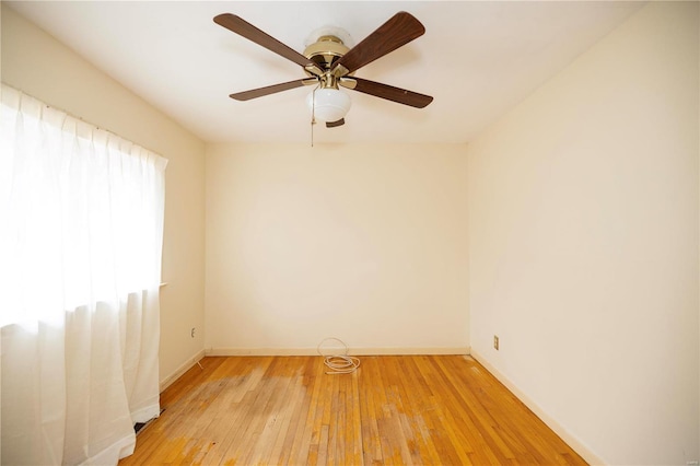 empty room with light wood-style floors, ceiling fan, and baseboards