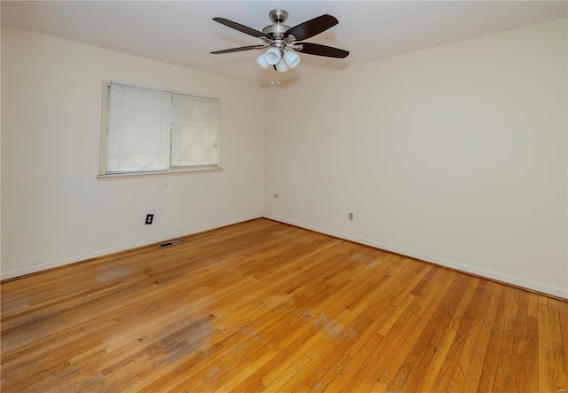 spare room featuring light wood-type flooring, baseboards, visible vents, and ceiling fan