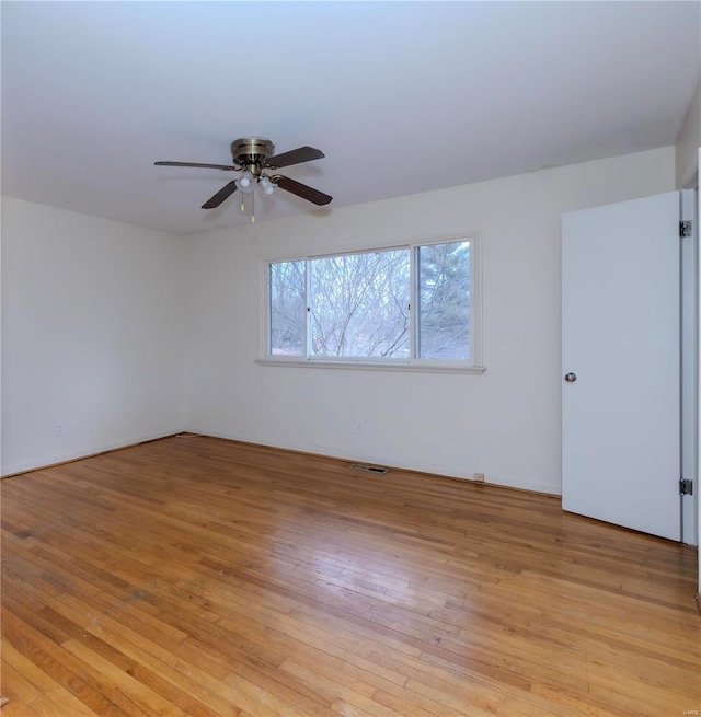 unfurnished room featuring ceiling fan, visible vents, and light wood-style floors