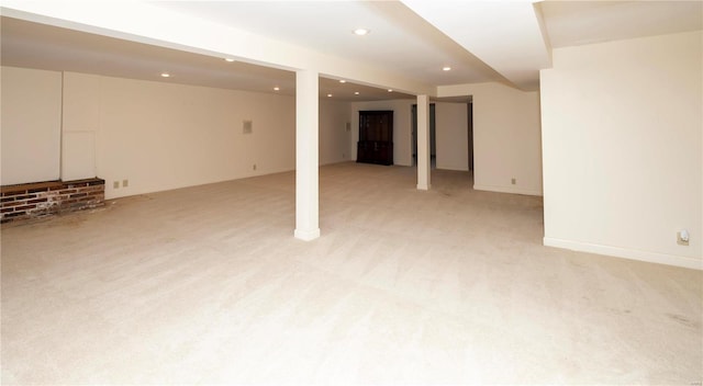 finished below grade area with light carpet, baseboards, and recessed lighting