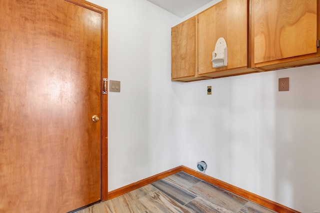 clothes washing area featuring light wood finished floors, cabinet space, electric dryer hookup, and baseboards