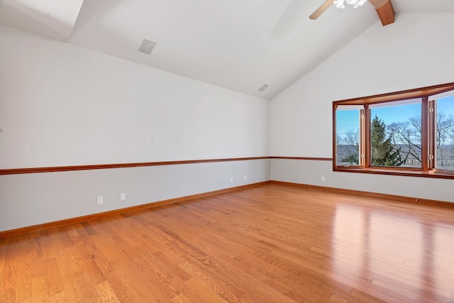 empty room featuring light wood-type flooring, baseboards, and vaulted ceiling with beams