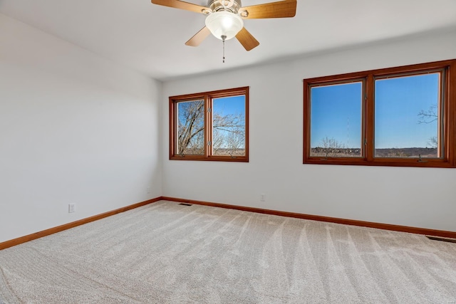 spare room with baseboards, carpet floors, and visible vents