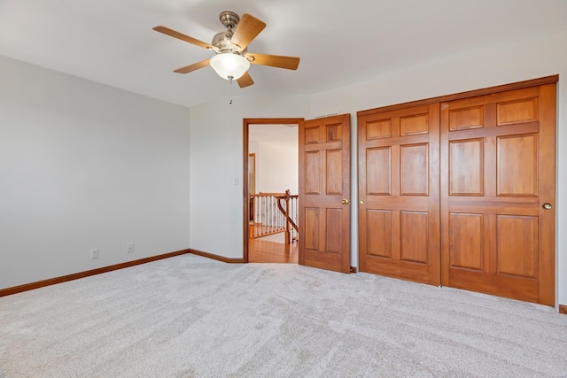 unfurnished bedroom with baseboards, carpet, and a ceiling fan