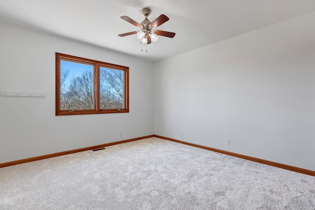 unfurnished room with visible vents, ceiling fan, baseboards, and carpet