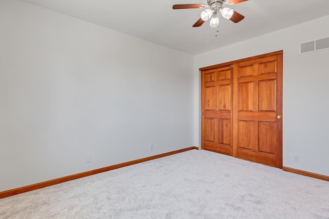 unfurnished bedroom with baseboards, visible vents, carpet floors, and ceiling fan