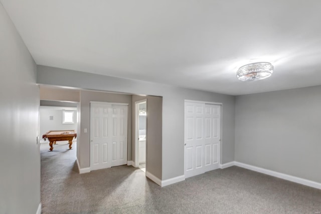 carpeted bedroom featuring pool table, two closets, and baseboards