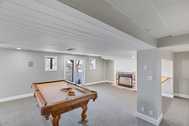 recreation room featuring a brick fireplace, baseboards, and carpet floors