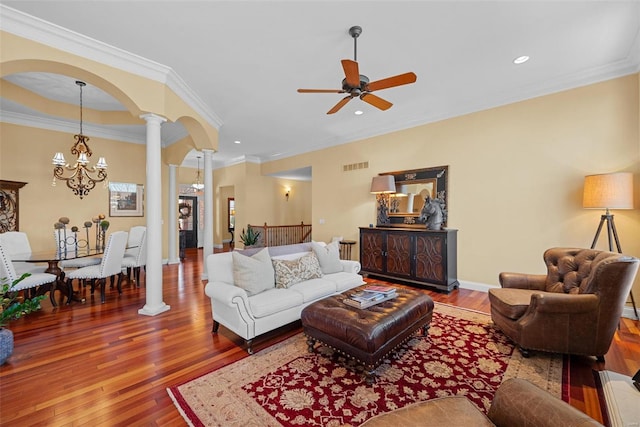 living room featuring arched walkways, visible vents, ornamental molding, wood-type flooring, and ornate columns