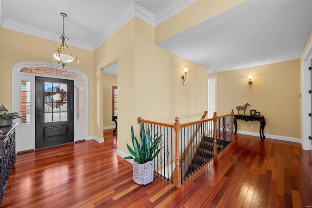 entrance foyer featuring baseboards, crown molding, and hardwood / wood-style floors