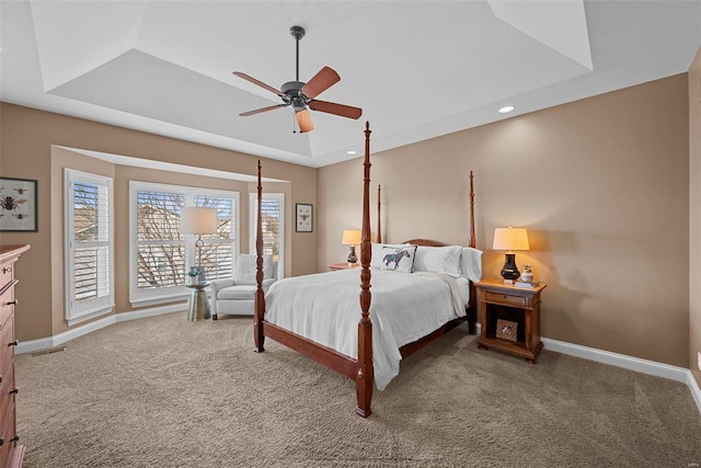 carpeted bedroom featuring ceiling fan, recessed lighting, visible vents, baseboards, and a raised ceiling