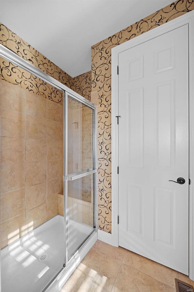 full bath featuring wallpapered walls, visible vents, baseboards, tile patterned floors, and a shower stall