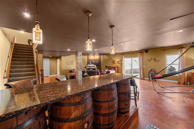 bar with recessed lighting, baseboards, hanging light fixtures, stairway, and finished concrete floors