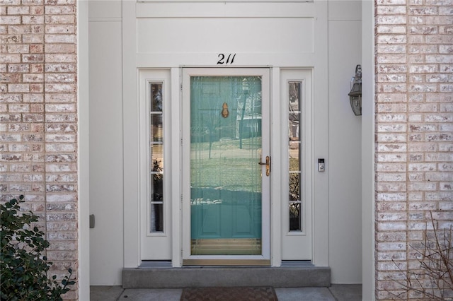 doorway to property featuring brick siding