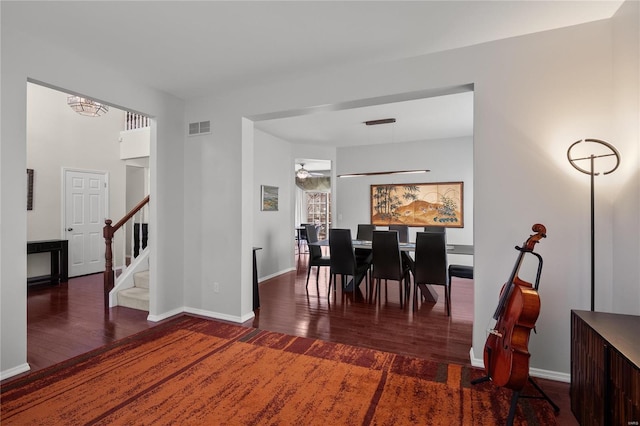 dining room featuring visible vents, stairs, baseboards, and wood finished floors