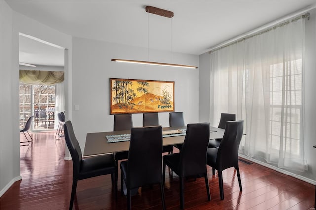 dining room featuring visible vents, baseboards, and dark wood-style flooring