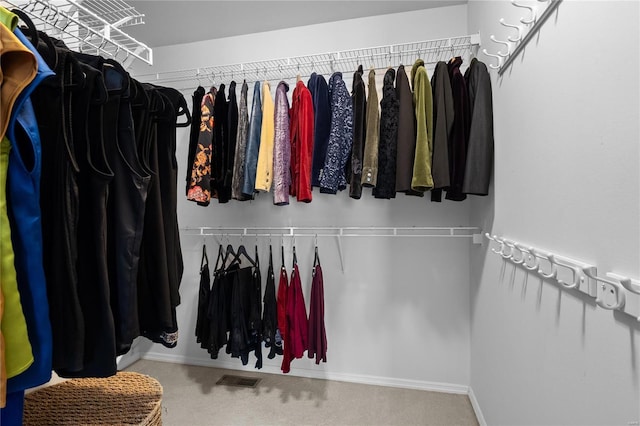 walk in closet featuring visible vents and carpet floors