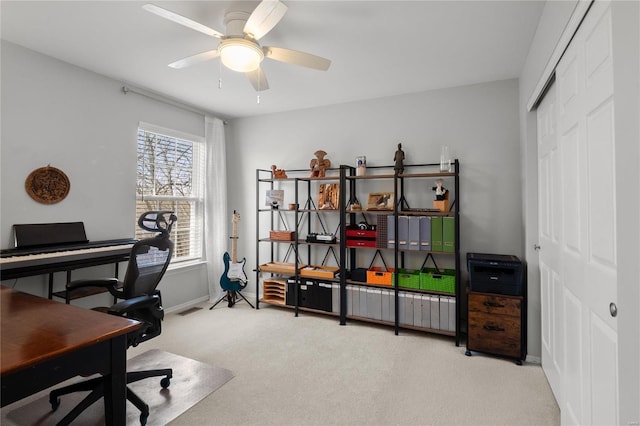 carpeted home office with a ceiling fan, visible vents, and baseboards