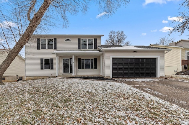 traditional-style house featuring an attached garage and driveway