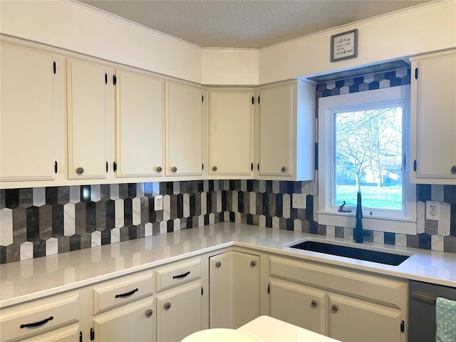 kitchen with decorative backsplash, dishwasher, light countertops, a textured ceiling, and a sink