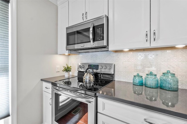 kitchen featuring white cabinetry, decorative backsplash, and appliances with stainless steel finishes