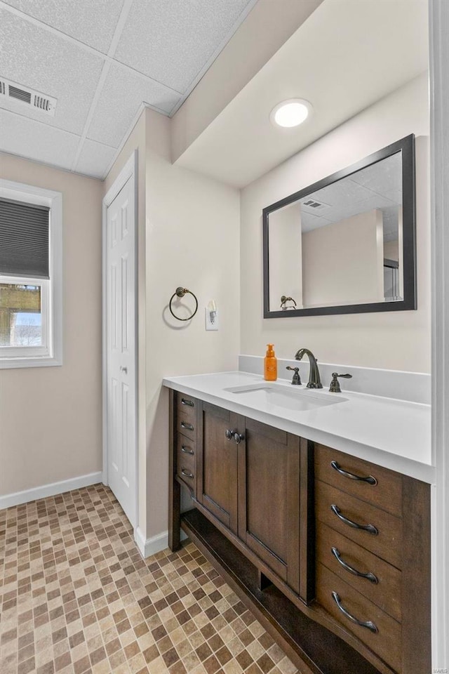 bathroom with vanity and a drop ceiling