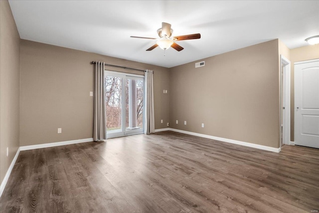 spare room featuring dark hardwood / wood-style flooring and ceiling fan