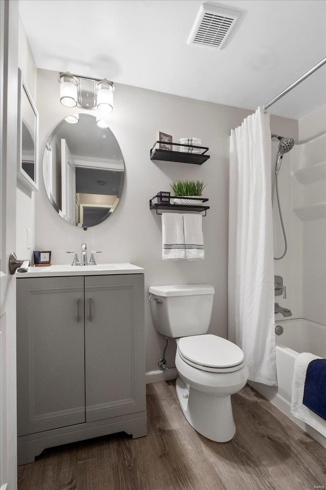 full bathroom featuring vanity, wood-type flooring, toilet, and shower / bath combo with shower curtain