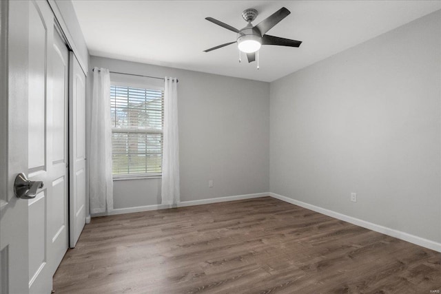 unfurnished bedroom featuring a closet, dark hardwood / wood-style floors, and ceiling fan