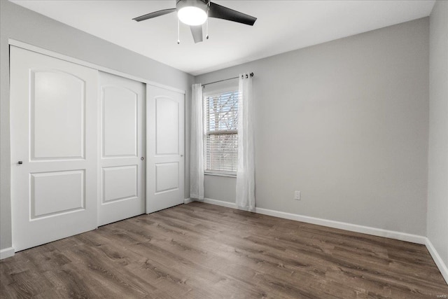 unfurnished bedroom with hardwood / wood-style flooring, a closet, and ceiling fan