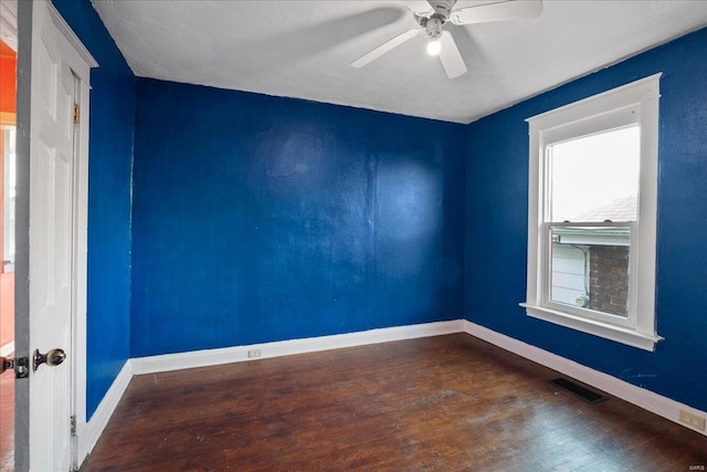 empty room with ceiling fan and dark hardwood / wood-style flooring