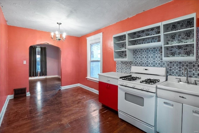 kitchen featuring tasteful backsplash, white gas range, dark hardwood / wood-style floors, and hanging light fixtures