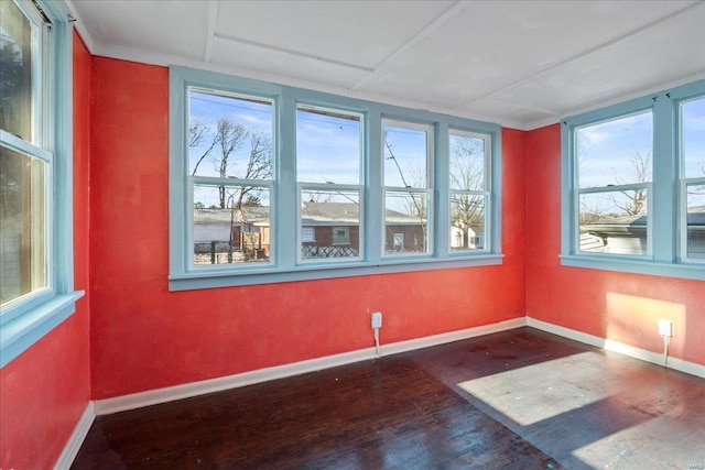 spare room featuring plenty of natural light and dark hardwood / wood-style floors