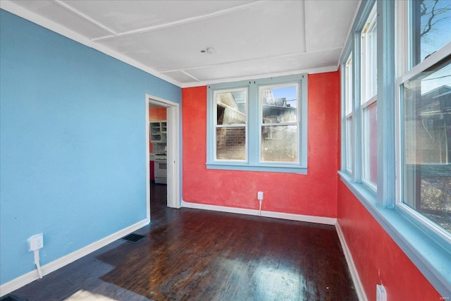 empty room featuring dark hardwood / wood-style flooring and a wealth of natural light