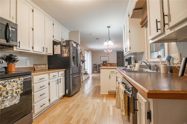 kitchen with stainless steel appliances, decorative light fixtures, sink, and white cabinets