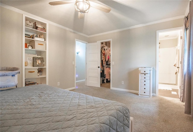 bedroom with ensuite bathroom, a walk in closet, light carpet, ornamental molding, and a closet