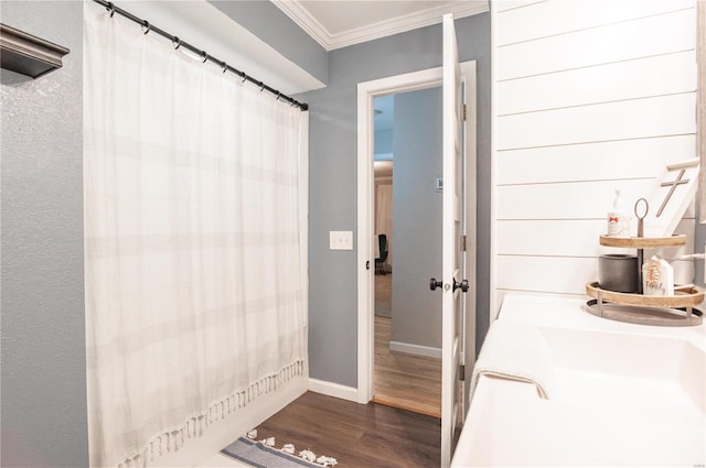 bathroom with hardwood / wood-style flooring and crown molding