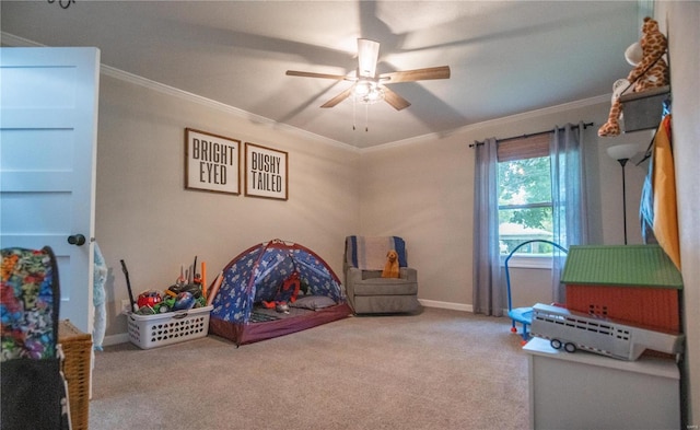 rec room featuring ornamental molding, ceiling fan, and carpet