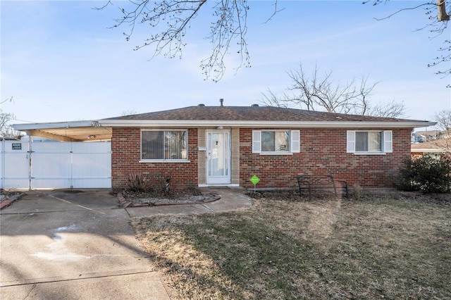 single story home with driveway, a front yard, fence, and brick siding