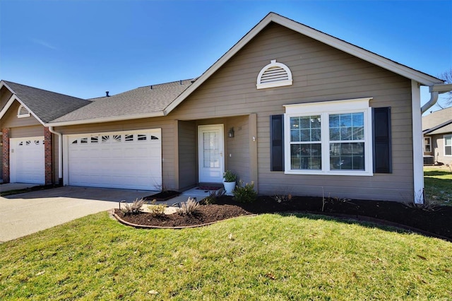 view of front facade with an attached garage, a shingled roof, a front lawn, and concrete driveway