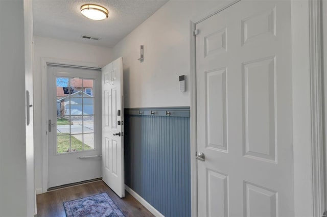 entryway with visible vents, dark wood finished floors, and a textured ceiling