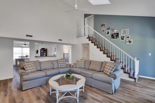 living room with stairway, a skylight, wood finished floors, and visible vents